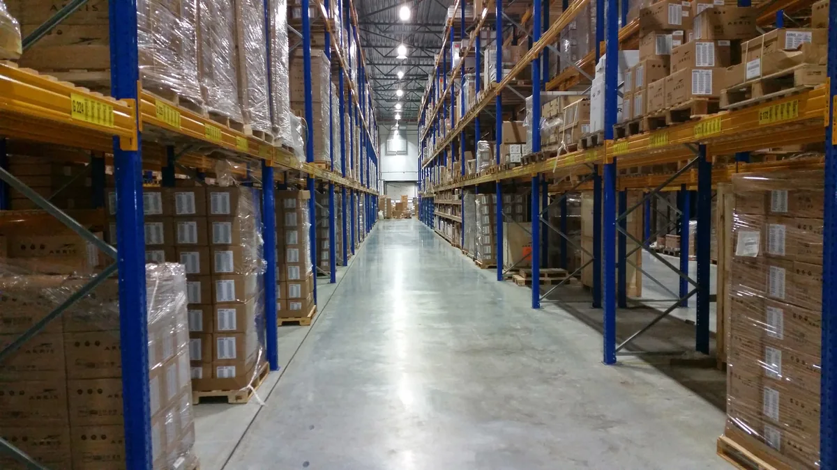 Storage racks with pallets and cardboard boxes along a warehouse aisle